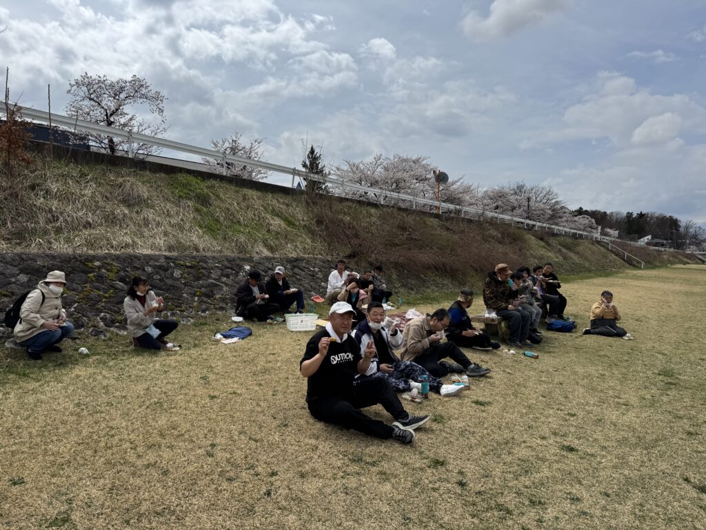 土手で食事をする利用者2