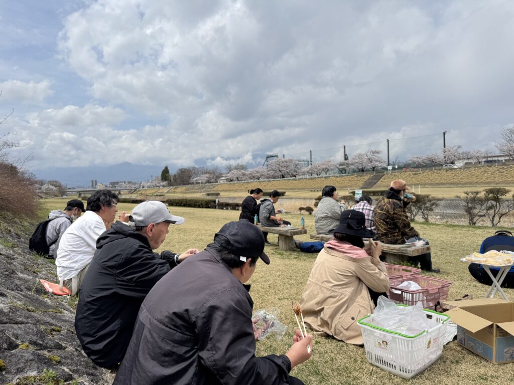 土手で食事をする利用者